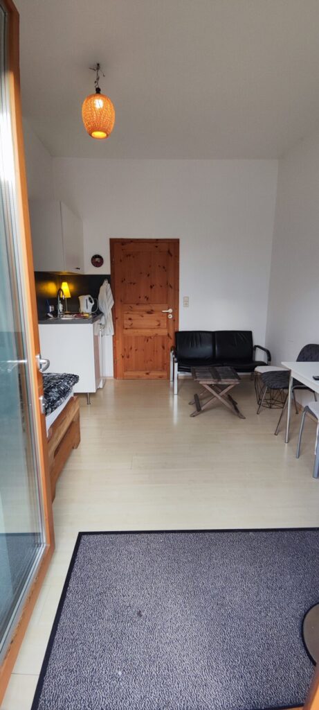 Apartment_mit_Sitzbank_Tisch_Bett_TV_Kueche_Bad_WC